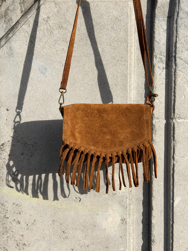 camel kleurige suede tas met franjes. Tas sluit met rits. Hengsel verstelbaar.