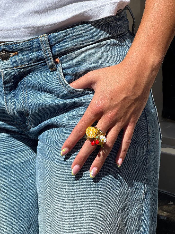 goudkleurige roestvrij staal ring met bedels, oa sinasappel, kers, bloem.