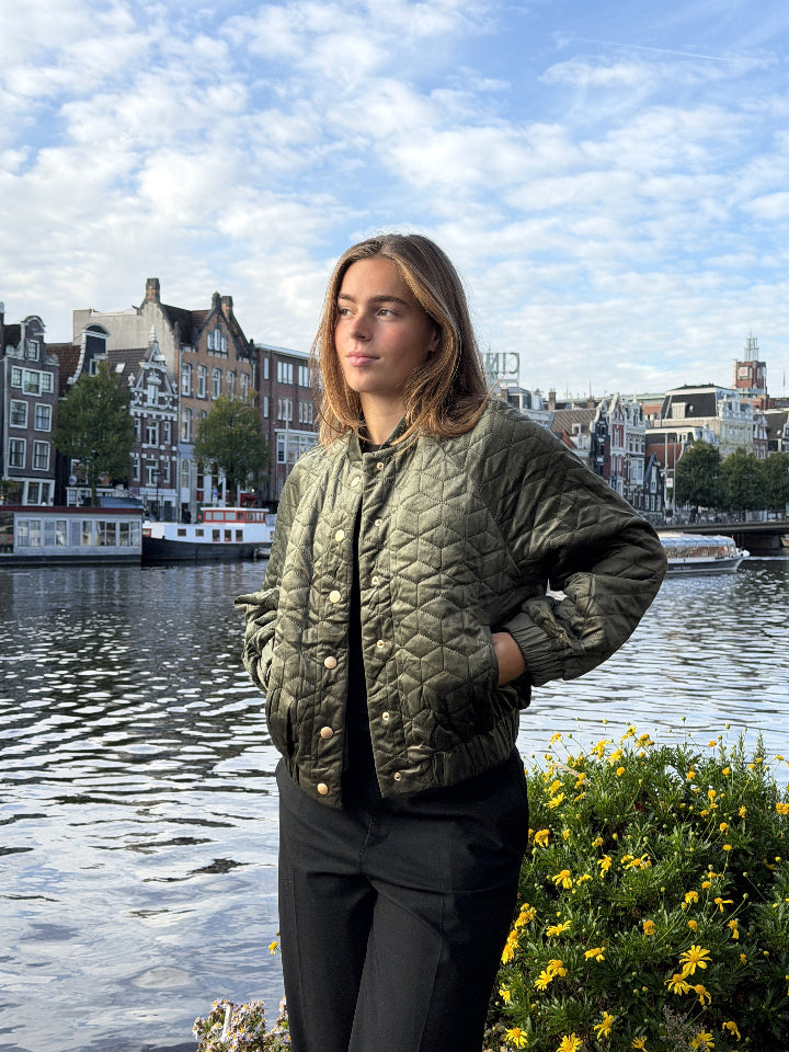 groen jackje met drukkers en twee zakken. Step effect, elastiek aan onderzijde