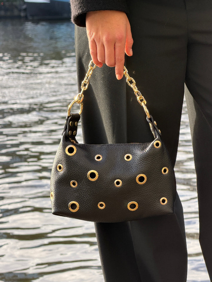 zwart leren tasje met goudkleurige metalen ringen in verschillende afmetingen.